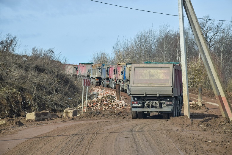 На фото - грузовики, засыпающие полигон ТБО «Летово»